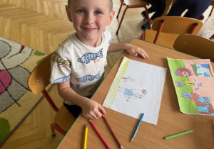 Chłopiec prezentuje swój rysunek do bajki