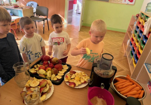 Dzieci robią soki z jabłek i marchewki