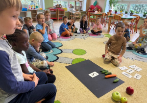 Chłopiec układa warzywa do danej cyfry
