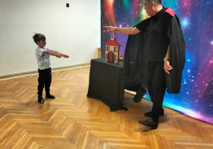 Pan czarodziej uczy chłopca magicznej sztuczki