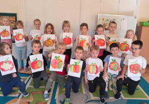 Dzieci prezentują swoją pracę plastyczną -jabłko malowane farbami