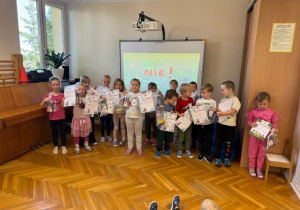 Dzieci pozują do zdjęcia z dyplomami i nagrodami