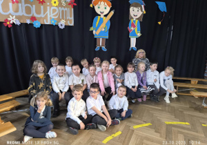 Dzieci siedzą na ławeczkach na Uroczystości w SP nr 79