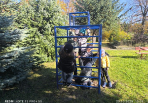 Dzieci w ogrodzie wspinają się na drabinkę