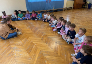 Dzieci siedzą w kole na podłodze i słuchają o życiu torbacza -lotopałanki