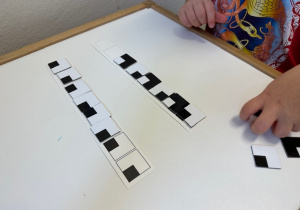 Dziecko układa kwadraty według wzoru