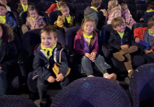 zieci siedzą w fotelach czekając na przedstawienie