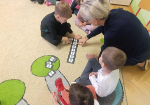 Chłopiec układa paradygmat z sylabami "ma, mo, mu, mó, mi, me, my"