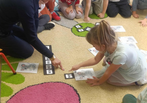 Dziewczynka układa paradygmat z sylabami "ma, mo, mu, mó, mi, me, my"