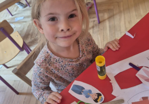 Dziewczynka wycina sylwetę postaci z papieru