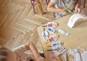 Dzieci wycinają sylwety postaci z bajek z papieru