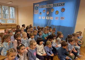 Dzieci siedzą na ławeczkach i rozmawiają o prawach dziecka