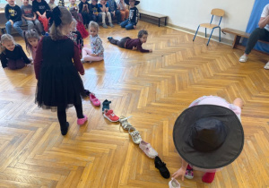 Dzieci ustawiają buciki do zabawy pt. "Kto pierwszy wyjdzie za mąż?"