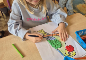 Dziewczynka ozdabia sylwetę papugi