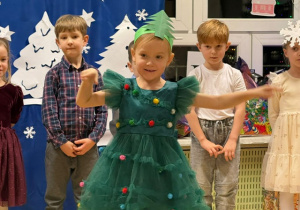 Dziewczynka przebrana za choinkę recytuje wiersz