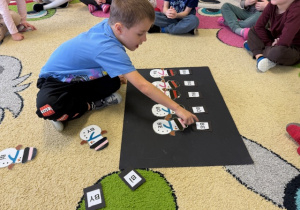 Chłopiec układa sylabę z sylwetą bałwanka do sylaby