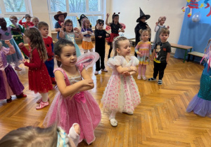 Dzieci tańczą i wymachują rękoma do muzyki dziecięcej