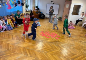 Dzieci biegają po sali wokół serduszek ułożonych na podlodze