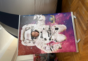 Dziewczynka pozuje do zdjęcia w fotobudce -Kosmonauta