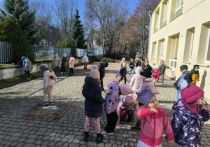 Dzieci rysują kredą w ogrodzie przedszkolnym