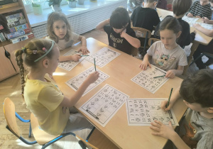 Dzieci wykonują matematyczne zabawy