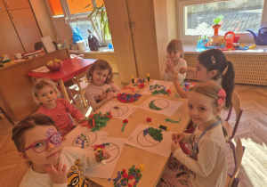 Dziewczynki wykonują z kulek bibuły piłkę