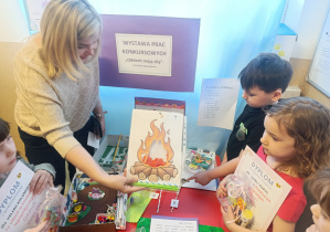 Pani Ewa objaśnia dzieciom sposób wykonania pracy plastycznej