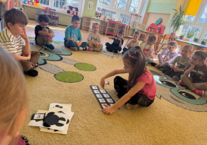 Dziewczynka układa paradygmat z sylab "ga, go, gu, ge, gi"