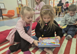 Dzieci oglądają książeczki z biblioteki