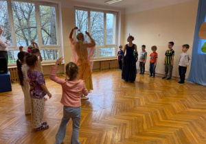 Dziewczynki i chłopcy naśladują ruchy tancerek